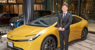 Toyota Prius chief engineer Satoki Oya holds the Japan Car of the Year trophy