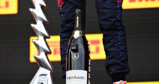 Verstappen with the winner's trophy and a Ferrari Trento celebration bottle